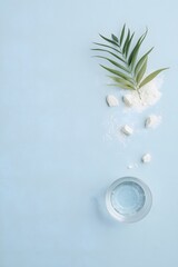 Top view of glass water cup with ice cubes and green leaves on light blue background, symbolizing freshness, hydration, purity, and clean natural wellness concept for health, spa, and eco-friendly des