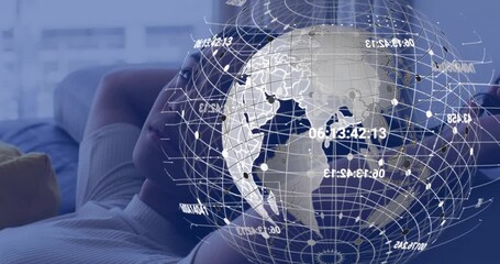 Male model reclining on sofa using phone causing globe speeding up overlay updating in tech demo - Powered by Adobe