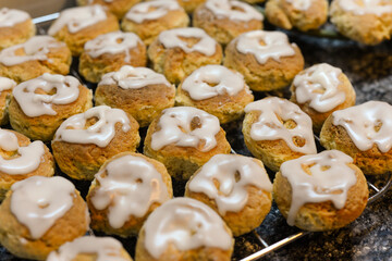 Homemade donuts with icing cooling on a wire rack in kitchen