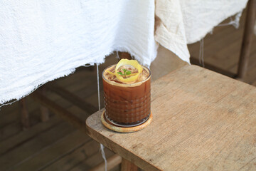 Tropical iced lemonade coffee on wooden table. Homemade cold summer Refreshing healthy drink.