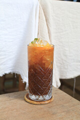 Tropical iced lemonade coffee on wooden table. Homemade cold summer Refreshing healthy drink.