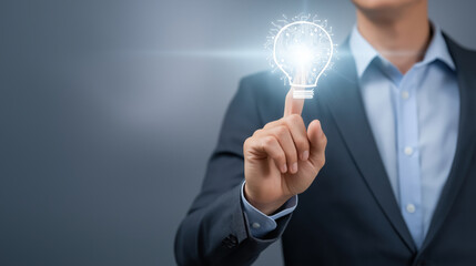 Businessman touching glowing digital lightbulb symbolizing innovation creativity and technology solutions in modern business strategy.