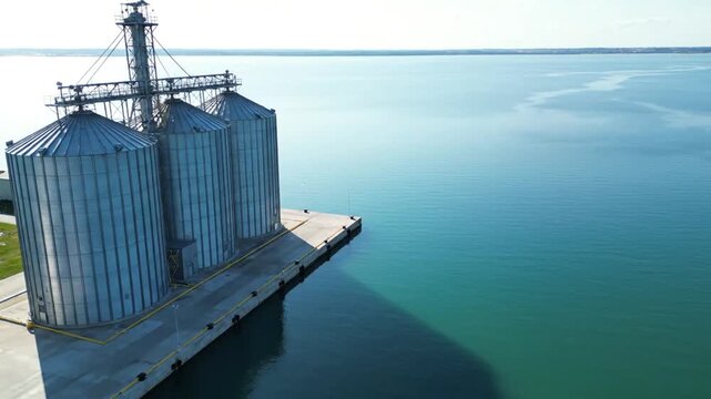 Stunning Aerial Drone View of Modern Grain Silos at a Commercial Seaport on a Sunny Day