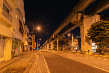 オレンジ色の街灯が明るい深夜のモノレールのレールと道路