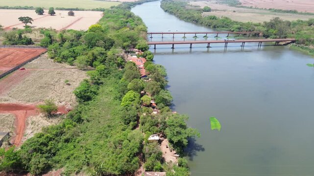 Drone view of Rio Pardo river with bridge and preserved native vegetation in Barretos and Gua&iacute;ra, S&atilde;o Paulo, Brazil