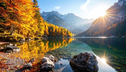 Scenic Lake Surrounded by Colorful Autumn Trees with Mountain Backdrop and Sunburst Reflection in Smooth Water in Alpine Landscape