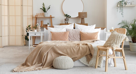 Stylish interior of bedroom with comfortable bed and chair with cushion