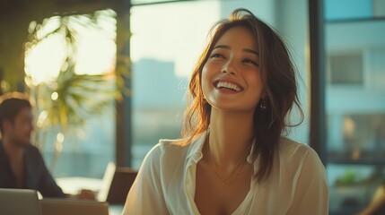 A woman in a white shirt enjoys a sunny day inside an office space.