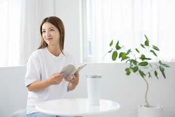 Woman reading book and smiling in bright room