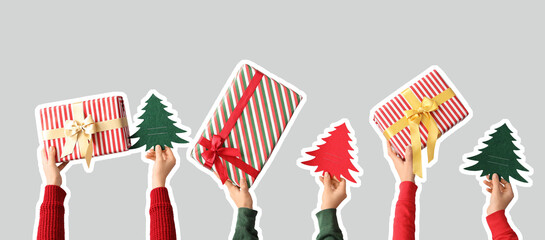 Female hands with gift boxes and paper Christmas trees on grey background