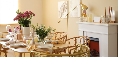 Beautiful table setting with flowers and fireplace for wedding celebration in room