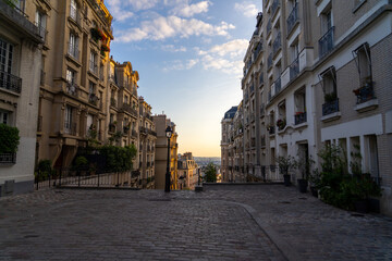 Parisian street with buildings and cobblestones at sunset.