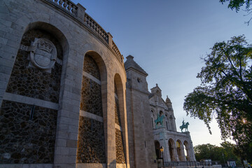 Sacre-Cœur Basilica in Paris at sunset with equestrian statues.