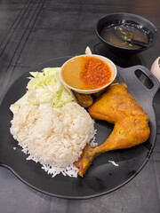 Steamed rice with fried chicken and sambal.