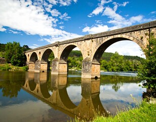 Fototapeta premium Stone arch bridge reflecting on a river