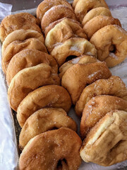Freshly fried doughnuts dusted with sugar.