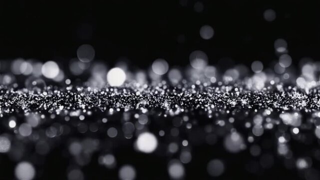 Close up of silver glitter particles with bokeh effect on a dark black background surface view bokeh light blur background patterns video
