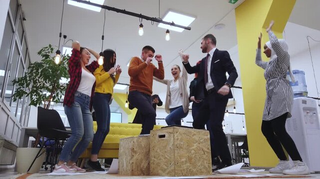 A diverse group of cheerful business people in a modern office celebrate their team's success with joyous jumps and shouts, embodying achievement, collaboration, in their professional environment.
