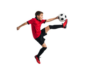 A young soccer player in mid-air about to kick the ball. The photo captures the action and intensity of the sport.
