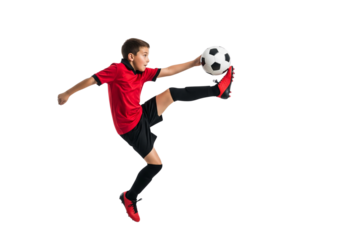 A young soccer player in mid-air about to kick the ball. The photo captures the action and intensity of the sport.