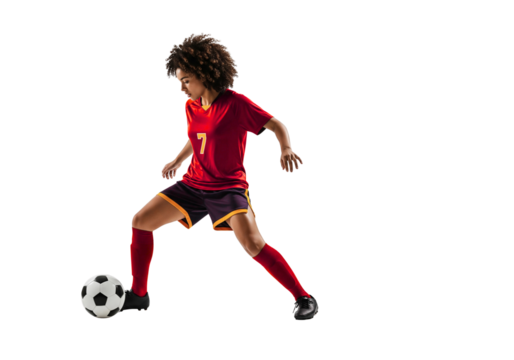 A focused female soccer player dribbling the ball