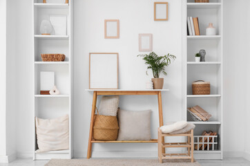 Interior of living room with wooden bench and different home decor in shelving units