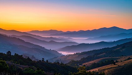 Serene Mountain Range at Sunrise with Colorful Sky and Misty Valleys Aerial View
