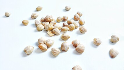 High angle view of Candlenut seed or biji kemiri (Aleurites moluccanus). Isolated on white background with copy space. Suitable for design element, food article, or health concept.