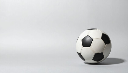 Fototapeta premium A soccer ball positioned on a simple paper texture background with ample copy space for creative designs and use