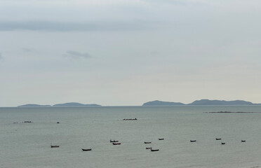 high angle seascape with boats and island moody sky