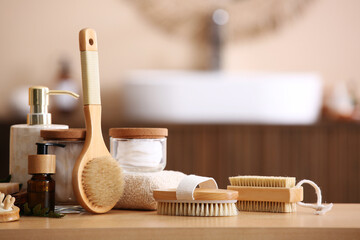 Set of spa accessories with different massage brushes on wooden table in bathroom