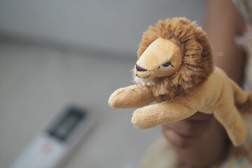 Child holds soft lion toy in a cozy indoor setting
