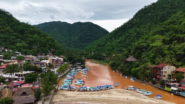 toma aerea de Boca de Tomatl&aacute;n, d&iacute;a niblado rio de color marron por las lluvias, vista desde un dron, zoom out, barcos y lanchas peque&ntilde;as, monta&ntilde;as verdes rodeada de selva