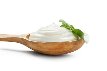 Wooden spoon with tasty sour cream and fresh basil on white background