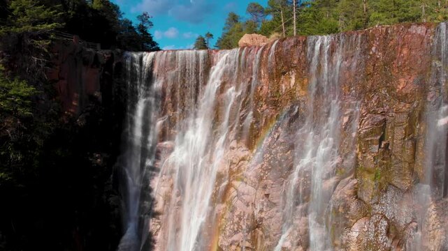 tilt up con dron de la Cascada de Cus&aacute;rare serca de el pueblo de creel en el estado de Chihuahua M&eacute;xico, verano con cielo azul, cascada en medio del bosque