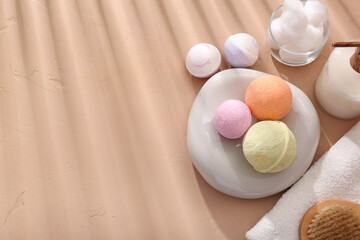 Composition with towel, stone and different bath bombs on beige background, closeup