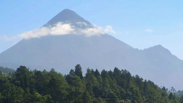 Un volc&aacute;n imponente bajo un cielo azul brillante.