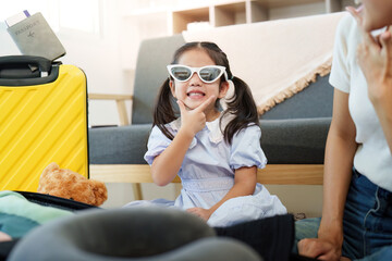 Family Travel. Child joyfully preparing for vacation with teddy bear.