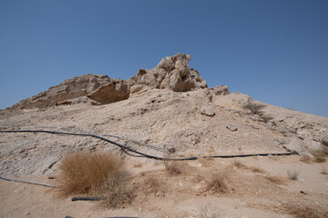 Scenic landscapes and mountain roads around Jebel Hafeet in Al Ain, United Arab Emirates, showing desert terrain, rocky hills, and winding routes under clear skies.