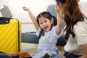Family Travel. Joyful child preparing for vacation with luggage and teddy bear.