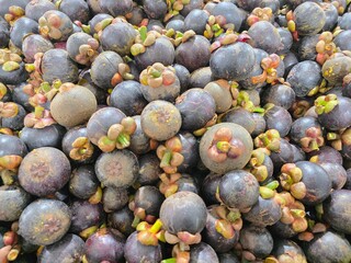 Pile of mangosteen fruit displayed in grocery store