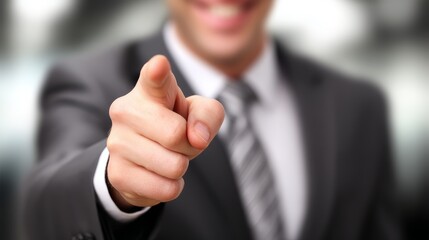 Confident businessman in suit points at viewer, professional man in sharp suit gestures directly engaging audience.