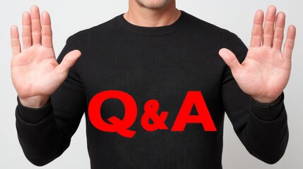 A person wearing a black sweater stands with both palms raised in a stop or surrender gesture, with the large, bold red text "Q&A" overlaid on their chest.