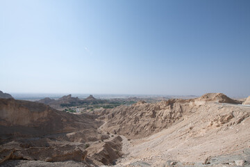 Scenic landscapes and mountain roads around Jebel Hafeet in Al Ain, United Arab Emirates, showing desert terrain, rocky hills, and winding routes under clear skies.
