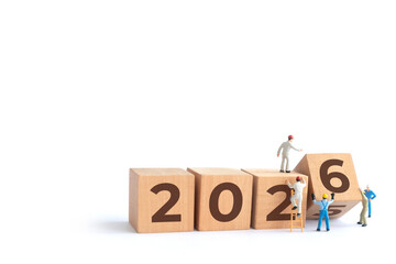 Transitioning from 2025 to 2026 with wooden blocks and miniature people. new year 2026 concept with white background.