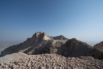 Scenic landscapes and mountain roads around Jebel Hafeet in Al Ain, United Arab Emirates, showing desert terrain, rocky hills, and winding routes under clear skies.