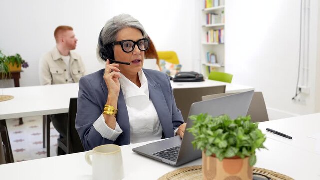 Senior businesswoman providing customer service on a headset