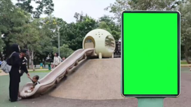 A wrinkled green poster template in the middle of an modern  park where children play on slides and swings. A glued paper mockup. A blank city park art sticker mockup. A clear glued urban advertising