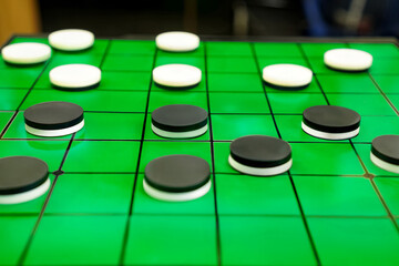Checkers Game Close-up with Black and White Pieces