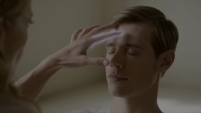 A woman hypnotizing a man